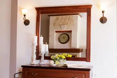 a mirror on a dresser with candles and flowers at Patriko Villa in Kissamos