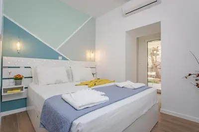 a bedroom with a large white bed with towels on it at Little gem by the sea in Chania Town