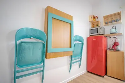 a room with two chairs and a red refrigerator at Little gem by the sea in Chania Town