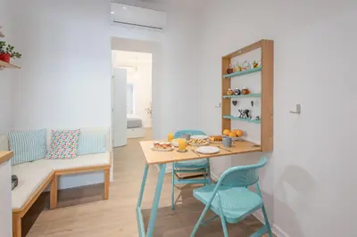a living room with a table and chairs and a couch at Little gem by the sea in Chania Town