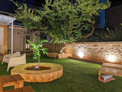 a garden with a tree in the middle of a yard at Little gem by the sea in Chania Town