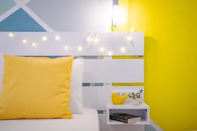 a bedroom with a bed with a yellow pillow and lights at Oasis by the sea in Chania Town