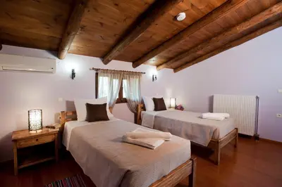 two beds in a room with wooden ceilings at Citrea Villa in Fournés