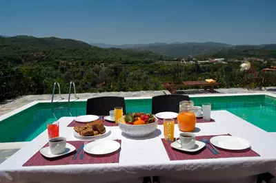 a white table with food and drinks and a bowl of fruit at Citrea Villa in Fournés