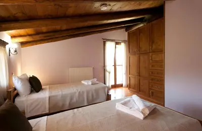 a bedroom with two beds and a large window at Citrea Villa in Fournés