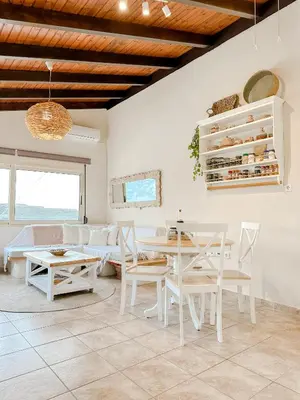 a living room with a table and chairs and a couch at Mountain Bliss Guesthouse 1 next to Sougia in Agrilés