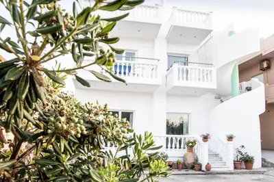 a white building with plants in front of it at Papidakis Studios in Agia Marina Nea Kydonias