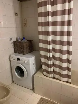 a washing machine in a bathroom with a shower curtain at Stelios house in Chania Town