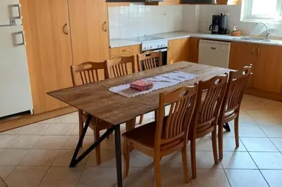 a kitchen with a wooden table and wooden chairs at Stelios house in Chania Town