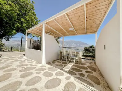 a patio with two chairs and a wooden roof at Mountain Bliss Guesthouse 2 next to Sougia in Agrilés