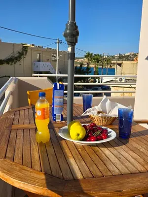 a table with a plate of food and a bottle of orange juice at Nora Apartment in Almyrida in Chania Town
