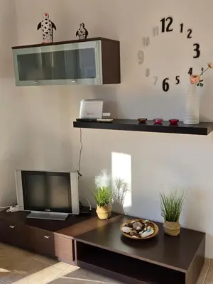 a living room with a tv and a table with a plate of food at Nora Apartment in Almyrida in Chania Town
