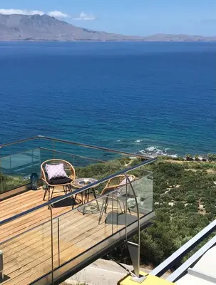 a balcony with a view of the ocean at Seafront Ravdoucha Epavlis Athina Villa - Pool, Gym, Sauna, Private Parking, WiFi in Ravdhoúkha
