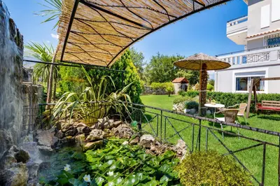 a garden with a waterfall and an umbrella at Villa Marianna in Vryses
