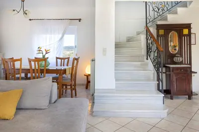 a living room with a staircase and a dining room at Villa Marianna in Vryses