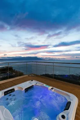 a hot tub on a balcony with a view of the ocean at Beachfront Ravdoucha Epavlis Eleni Villa - Pool, Hot Tub, Gym, Sauna, Private Parking, WiFi in Chania Town