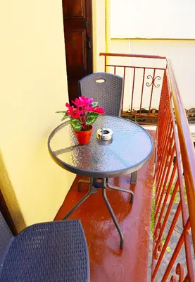 a table and two chairs and a table with flowers on a balcony at Calma Apartment Chania in Chania Town
