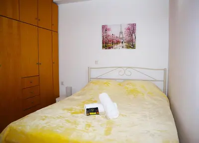 a bedroom with a yellow bed with a toy truck on it at Calma Apartment Chania in Chania Town