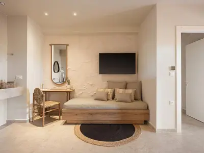 a bedroom with a bed with a television on the wall at Villa Agali I 