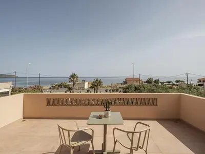 a table and chairs on a balcony with a view of the ocean at Villa Agali I 