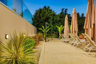 a row of chairs and umbrellas next to a building at Chris villa with private ecologic pool and kid's playground! in Chania Town