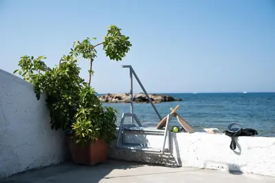 a swimming pool on the side of a wall next to the water at Seasound apartments in Galatás