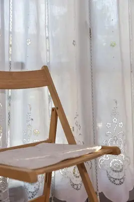 a wooden chair sitting in front of a window at Seasound apartments in Galatás
