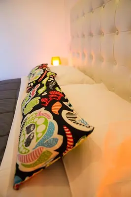 a bed with a colorful pillow on it at Villa Pandora - Angela & Michali in Maleme