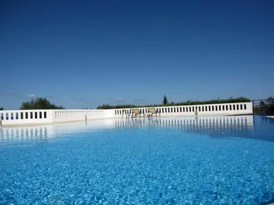 a large pool of blue water with a white wall at Villa Pandora - Angela & Michali in Maleme