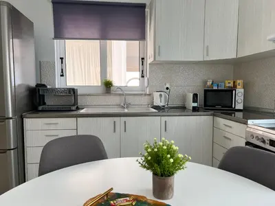 a kitchen with a table with chairs and a microwave at Veryhome in Maleme