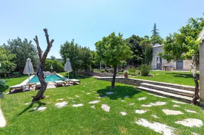 a garden with a swimming pool and trees at Athermigo Boutique Estate in Gavalochori