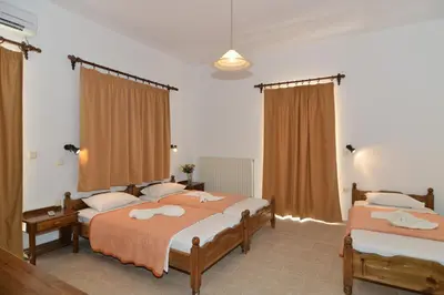 a bedroom with two beds and curtains at Niriida in Sfinárion