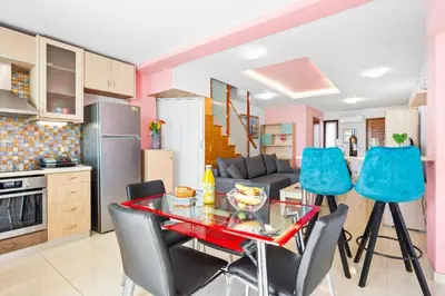 a kitchen and living room with a table and chairs at Emmanouel Maisonette near the Sea in Parigoría