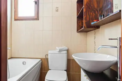 a bathroom with a white toilet and a sink at Emmanouel Maisonette near the Sea in Parigoría