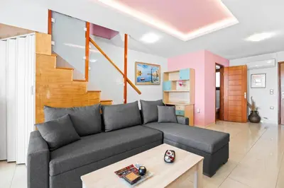 a living room with a couch and a staircase at Emmanouel Maisonette near the Sea in Parigoría
