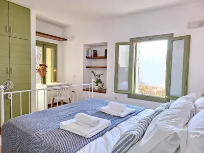 a white bedroom with a bed with towels on it at Icarus Loft Old Town rooftop terrace in Chania Town