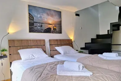 two beds in a room with a staircase at Icarus Loft Old Town rooftop terrace in Chania Town