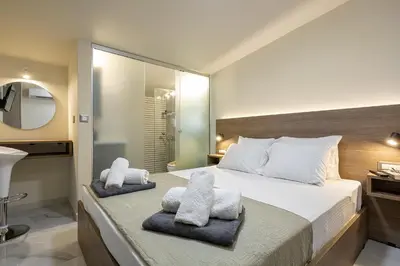 a bedroom with a large bed with towels on it at Chris and Stratos villa with private ecologic pool and kid's playground! in Mourniaí