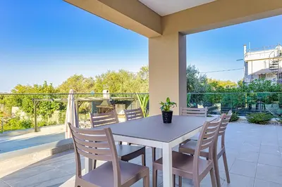 a white table and chairs on a patio at Chris and Stratos villa with private ecologic pool and kid's playground! in Mourniaí