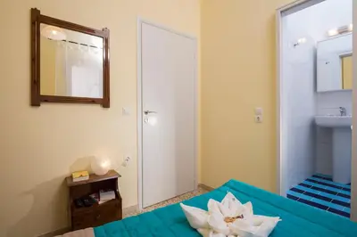 a bedroom with a blue bed with a mirror and a sink at Penelopi Rooms in Chania Town