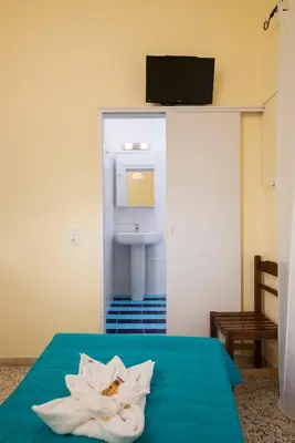 a room with a bed with a white flower on it at Penelopi Rooms in Chania Town