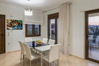 a dining room with a table and white chairs at Villa Katerina with Private Pool in Chania Town