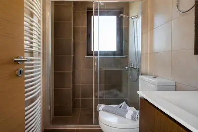 a bathroom with a shower and a toilet and a sink at Villa Katerina with Private Pool in Chania Town