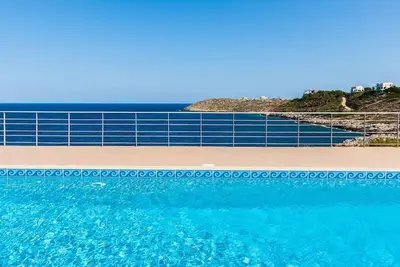 a swimming pool with the ocean in the background at Seascape in Tersanas