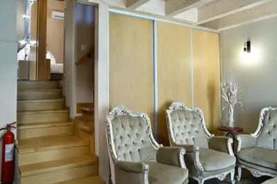 two white chairs in a hallway with a staircase at Alexandras's Mansion in Ayiá
