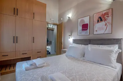 a bedroom with a large bed with wooden cabinets at Alexandras's Mansion in Ayiá