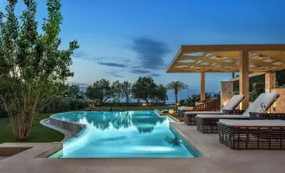 a swimming pool with lounge chairs and an umbrella at Villa Elvina in Kissamos