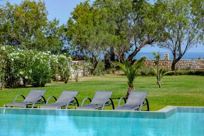 a group of chairs sitting next to a swimming pool at Villa Elvina in Kissamos