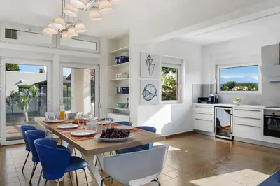 a kitchen and dining room with a table and chairs at Villa Elvina in Kissamos