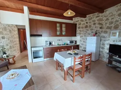 a kitchen with a white table and a white refrigerator at Rokka Pyrgos Amazing View - Maistros in Rókka